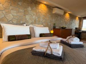 una camera da letto con un letto grande con asciugamani sopra di Wait 'N Sea, Jacuzzi, Luxury Stone House a Epanomi