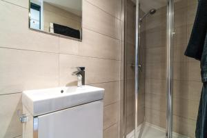 a bathroom with a sink and a shower at Villa Bellevue 10 Personnes in Arromanches-les-Bains +96 photos