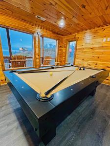 een pooltafel in een kamer met houten wanden bij 5 Star Views! Hot Tub! Game Room! Near Dollywood & Parkway in Sevierville