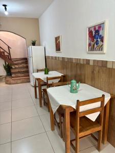 a dining room with two tables and a refrigerator at Pousada Roncador in Lençóis +9 photos