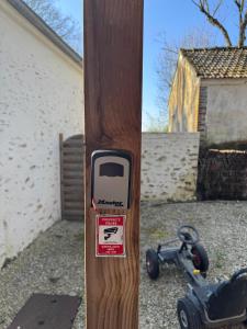 un palo di legno con un adesivo sopra accanto a uno scooter di Cedar Cottage - Disney 30min a Coulommiers