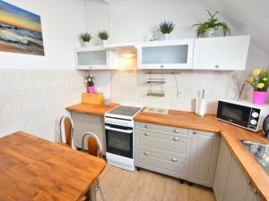 a kitchen with white cabinets and a wooden table at Holiday apartment, 3 bedrooms, garden, S owino in Słowino