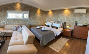 una camera con letto king-size e divano di Wait 'N Sea, Jacuzzi, Luxury Stone House a Epanomi Altre 45 foto