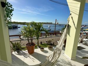 a hammock on a balcony with a view of the water at Mar à Vista Boipeba Frente Mar by LVF in Ilha de Boipeba