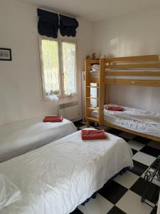 een slaapkamer met 2 stapelbedden en een geruite vloer bij Birchbank Cottage - Disney 30min in Coulommiers