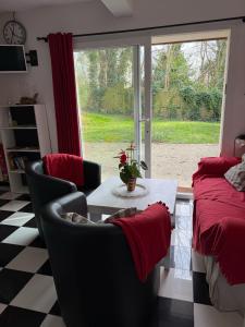 een woonkamer met een tafel en stoelen en een raam bij Birchbank Cottage - Disney 30min in Coulommiers