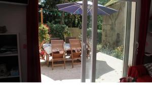 a patio with a table and an umbrella at Birchbank Cottage - Disney 30min in Coulommiers