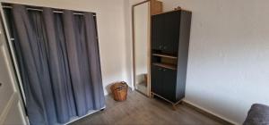 Zimmer mit einem Spiegel und einem schwarzen Schrank in der Unterkunft Top3 Ferienwohnung mit Fitnessstudio in Plauen