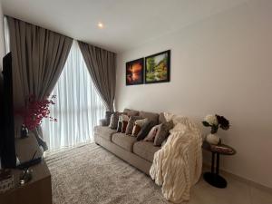アクラにあるLuxury 1 bedroom at Novaのソファと大きな窓のあるリビングルーム