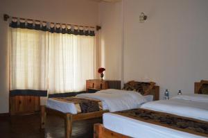 Uma cama ou camas num quarto em Chitwan Paradise Hotel