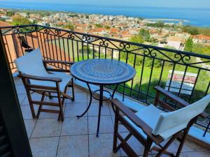 a balcony with a table and chairs and the ocean at Sunset Balcony in Kyparissia