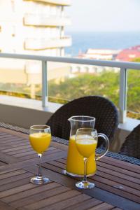 dos vasos de zumo de naranja sentados en una mesa en 203 Oyster Quays - by Stay in Umhlanga en Durban