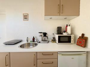 a kitchen counter with a sink and a microwave at Cozy guesthouse with outdoor space in Brabrand +3 photos