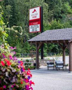 a gas station with benches and a sign for aadobeadobeadobeadobeadobeadobe at Swiss Chalet Motel in Revelstoke