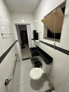 a bathroom with a toilet and a sink and a mirror at Beach House Cabo Frio Hostel in Cabo Frio +24 photos