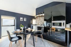 a kitchen with black walls and a table and chairs at Countryside Bliss Close To Dublin in Newcastle
