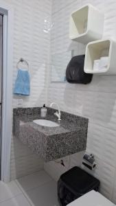 a bathroom with a sink and a toilet at Estilo resort para confraternizar com hidro, piscina, garagem em casa tudo privativo, insira acima de 6 hóspedes para usar os 3 quartos in Sorriso