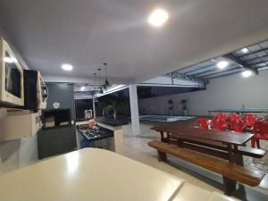 a living room with a table and red chairs at Estilo resort para confraternizar com hidro, piscina, garagem em casa tudo privativo, insira acima de 6 hóspedes para usar os 3 quartos in Sorriso