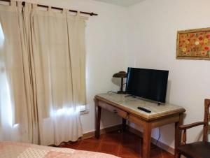 a room with a desk with a television on it at Aires serranos in Tandil