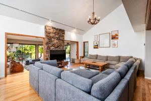 sala de estar con sofá grande y chimenea en Spacious Mountain View Oasis - Pool, Spa & Game Rm, en Oakhurst