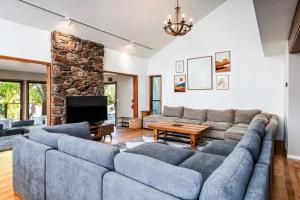 sala de estar con sofá grande y TV en Spacious Mountain View Oasis - Pool, Spa & Game Rm, en Oakhurst