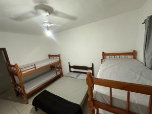 a bedroom with two bunk beds and a ceiling at Beach House Cabo Frio Hostel in Cabo Frio