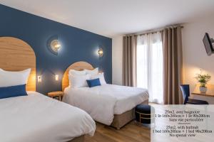 two beds in a hotel room with blue walls at Hôtel Flor in Saint-Florent