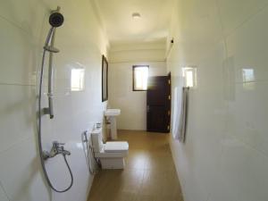 La salle de bains est pourvue de toilettes, d'un lavabo et d'une douche. dans l'établissement Hideaway Lodge, à Tangalle