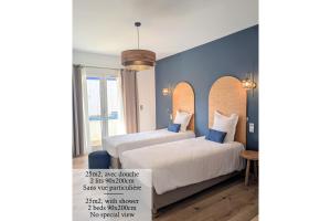 two beds in a room with blue walls at Hôtel Flor in Saint-Florent