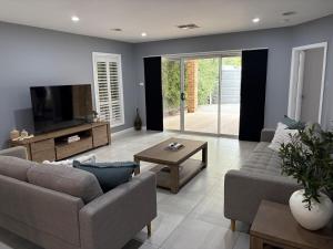 a living room with two couches and a television at The Goldsmith Retreat in Goulburn