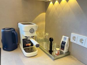 eine Kaffeemaschine, die auf einer Theke neben einer Kaffeekanne steht in der Unterkunft Frankfurt Messe Luxury Business Suit in Frankfurt am Main