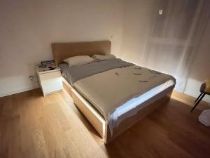 ein Schlafzimmer mit einem großen Bett und einem Nachttisch in der Unterkunft Frankfurt Messe Luxury Business Suit in Frankfurt am Main