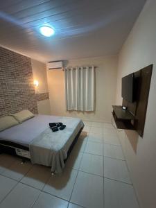 una camera da letto con un letto e una TV a schermo piatto di Suítes privativas a Cachoeiras de Macacu