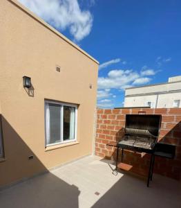 a barbecue grill sitting on the side of a building at Bungalows Casa Mansa 1 y 2 in Villa Elisa