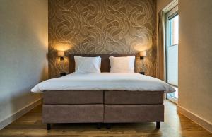 a bedroom with a bed with a wall with a flower pattern at Eilandhotel Texel - Nieuw geopend hotel in De Cocksdorp