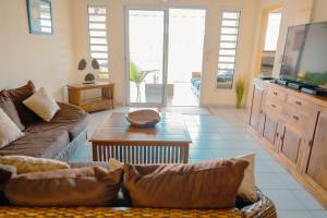 a living room with a couch and a table at Anse Caraïbes Appartement in Les Trois-Îlets