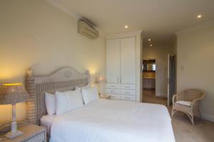 1 dormitorio con 1 cama blanca grande y 1 silla en 203 Oyster Quays - by Stay in Umhlanga en Durban