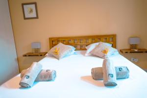 a white bed with towels on top of it at Anse Caraïbes Appartement in Les Trois-Îlets