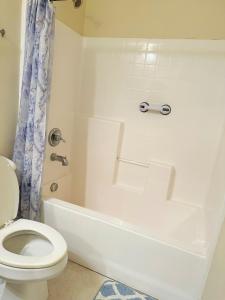 a white bathroom with a toilet and a tub and a sink at Pretty room private bathroom no tv in Eastvale