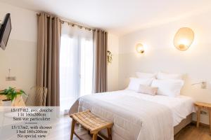 a bedroom with a white bed and a window at Hôtel Flor in Saint-Florent