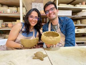 a man and a woman are holding a dough at VoyAca Hotel - Alfareria in Villa de Leyva