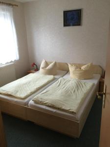 a bedroom with two beds with white sheets and a window at Ferienwohnung Wede in Ueckeritz