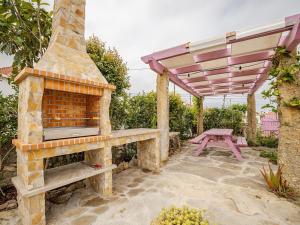 a patio with an outdoor oven and a picnic table at Casa das bonecas in Pernigem +27 photos