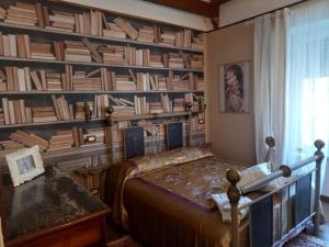 a bedroom with a bed and a wall of books at Le spighe dei papi in Anagni