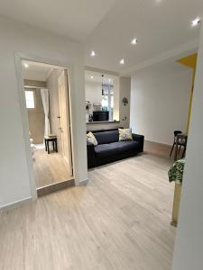 un salon avec un canapé noir et une cuisine dans l'établissement Il Giardino di Eva - a soli 280m dal treno ferroviario, à Casalnuovo di Napoli