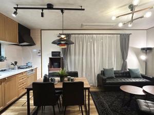 eine Küche und ein Wohnzimmer mit einem Tisch und einem Sofa in der Unterkunft わたか 雄琴温泉 Wataka Ogoto Onsen in Ōtsu