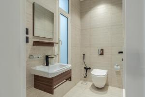 a bathroom with a white sink and a toilet at أكاريم أفينيوز Akareem Avenues in Riyadh +159 photos