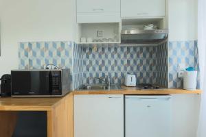 a kitchen with a microwave and a sink at Studio 2P Roland Garros Parc des in Boulogne-Billancourt