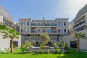 an apartment building with palm trees in front of it at أكاريم أفينيوز Akareem Avenues in Riyadh