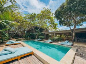 a swimming pool with two beds and a house at Villa Mango Jeri in Jericoacoara